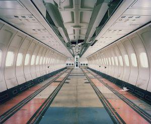 A Boeing 727 has been stripped of its interiors while its seats undergo maintenance and their covers are replaced. From the series "The LAB Project" © Nick Ballon.